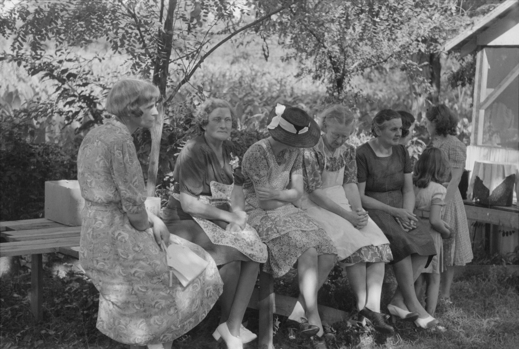 Women resting together after preparing a picnic supper near Bardstown, Kentucky, photographed by Marion Post Wolcott in 1940